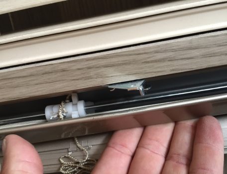 Bracket in the open position with the blind resting on it
